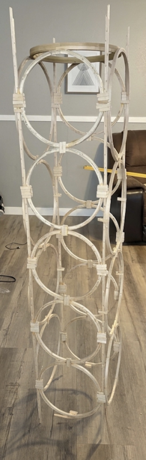 Seven stick rings laid out flat on carpet between two long rails, the rings growing thicker toward the bottom