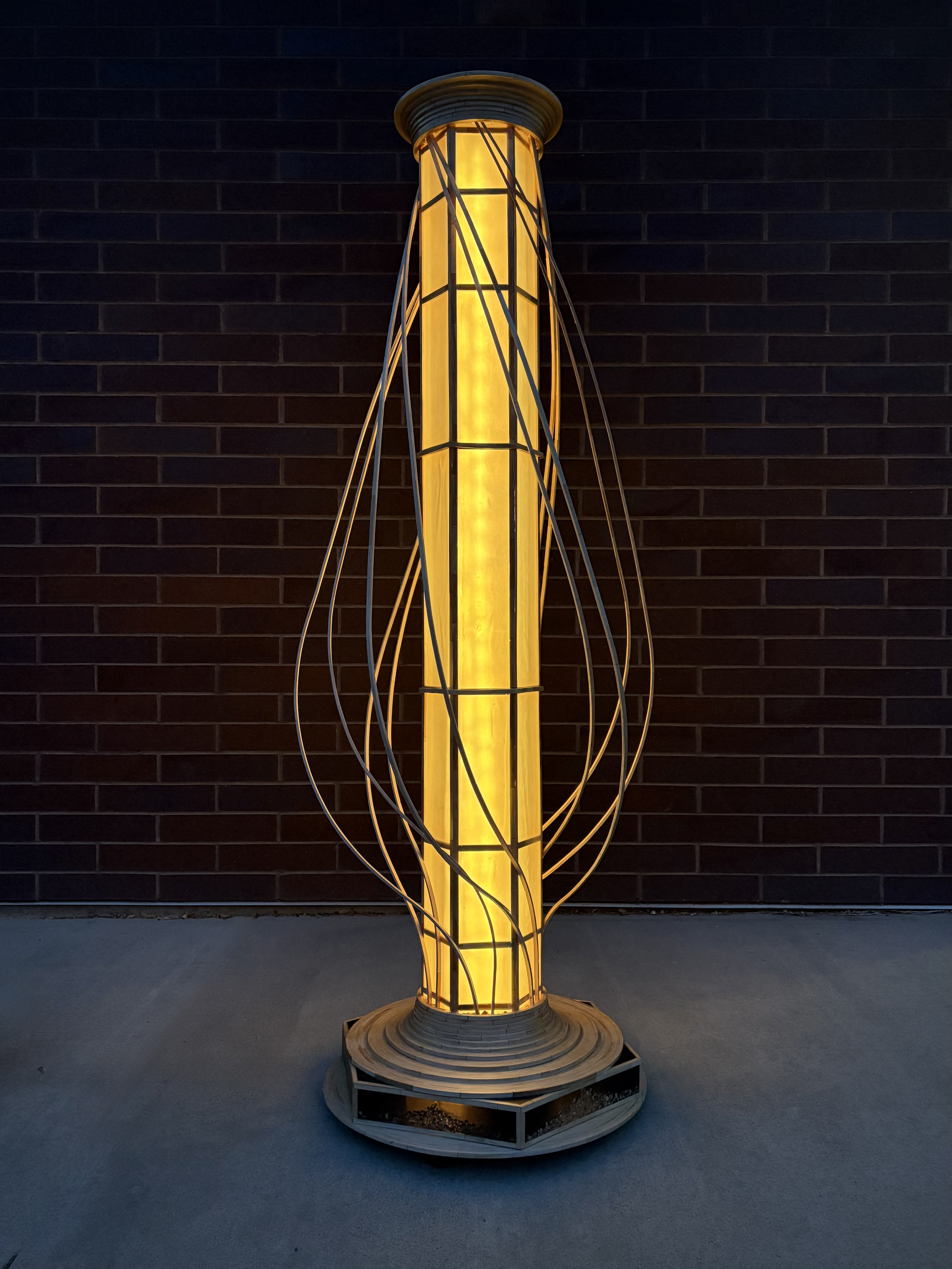 Vessel — 7ft 4in lamp sculpture lit with a brick wall background